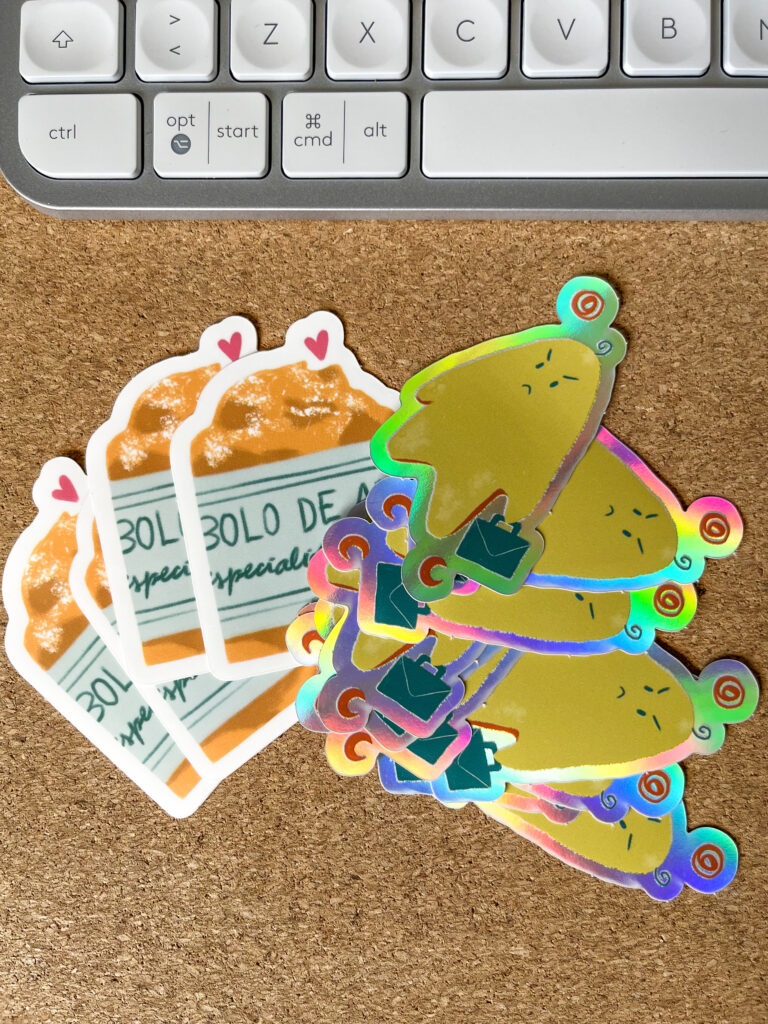 Autocolantes: bolo de arroz (4 exemplares) e fantasma (5 exemplares). No topo da imagem está um teclado branco, pelo que entendemos que a fotografia foi tirada num escritório.